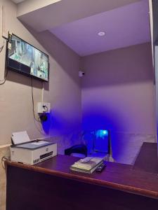 a room with a desk with a laptop and a tv at Laxmi Dham Guest House in Chhatikara