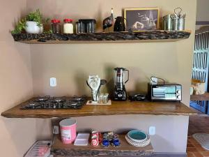 a kitchen with a counter with a stove on a shelf at Chalé Casa da Pedra in Cunha