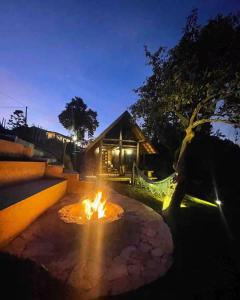 a fire pit in front of a house at night at Chalé Casa da Pedra in Cunha +2 photos