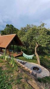 a hammock in a garden next to a pavilion at Chalé Casa da Pedra in Cunha