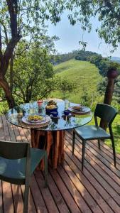 a table with plates of food on a wooden deck at Chalé Casa da Pedra in Cunha