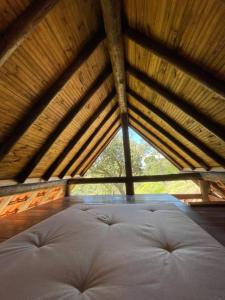 a large bed in a room with a wooden ceiling at Chalé Casa da Pedra in Cunha