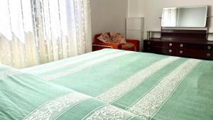 a bedroom with a green bed with a dresser and a television at SE081 - Comodo trilocale a Marotta in Marotta +7 photos