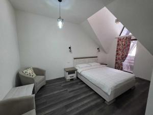 una camera da letto con un letto, una sedia e una finestra di Cabana OAZA AMURG a Runcu