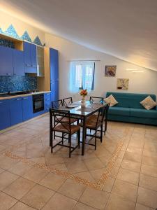 een keuken met een tafel en stoelen en een bank bij MARCONI APARTMENTS in Termoli