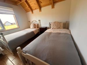 two beds in a room with a window at Cabañas RyL Aeropuerto in Puerto Montt