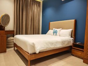 a bedroom with a bed with a blue wall at Villa Swenet in Aswan