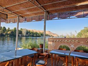 a restaurant on the water with tables and chairs at Villa Swenet in Aswan