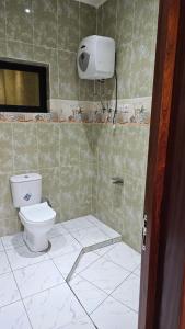 a bathroom with a toilet in a tiled room at Maison Jaspe in Brazzaville