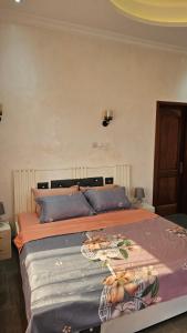 a bedroom with a large bed with blue pillows at Maison Jaspe in Brazzaville