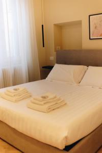 a white bed with two towels on top of it at Monti26 in Milan