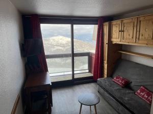 a room with a couch and a large window at Ancolie in Villarembert