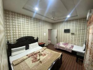 a bedroom with two beds and a tv in it at Lux Lodges Guest House in Islamabad