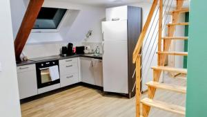 a kitchen with a white refrigerator and a staircase at La Grange de Pépé in Biltzheim