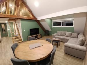 a living room with a table and a couch at La Grange de Pépé in Biltzheim