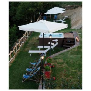 a table and chairs with an umbrella and a pool at Locanda Il Rustichello in Mulazzo