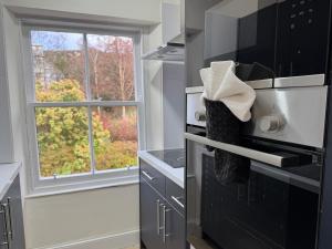 eine Küche mit einem schwarzen Backofen und einem Fenster in der Unterkunft Glenrigh House - Loch View Flat for 2 in Onich