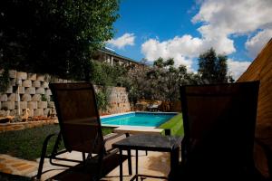 two chairs and a table next to a swimming pool at Noble Hearts Bed & Breakfast in Maseru