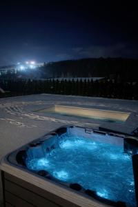 een jacuzzi op een patio 's nachts bij Willa Black Wood in Istebna