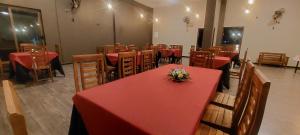 a dining room with tables and chairs with red table cloth at Orion Blue Hotel in Dombagahawatta +15 photos