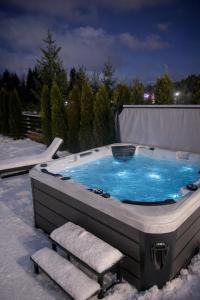 een jacuzzi met een stoel en een bankje bij Willa Black Wood in Istebna