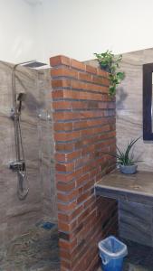 a brick wall with a shower in a bathroom at Orion Blue Hotel in Dombagahawatta