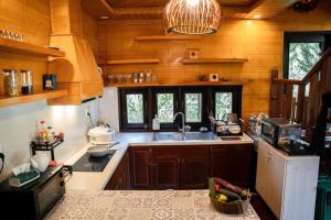 a kitchen with wooden walls and wooden cabinets and a sink at tinys house in Lạc Dương