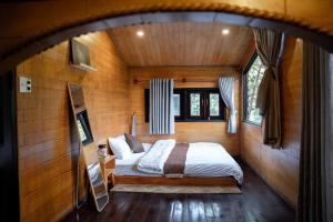 a bedroom with a bed in a wooden room at tinys house in Lạc Dương