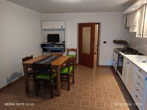 a kitchen with a table and chairs and a kitchen with a desk at La casa del Gianni in Piano