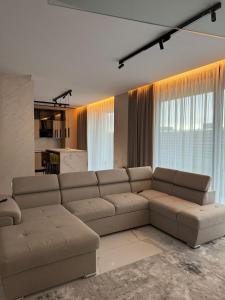 un soggiorno con un grande divano marrone in una camera di Knight Home a Voluntari