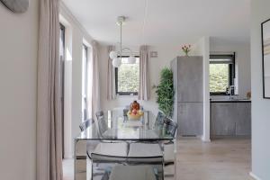 a dining room with a glass table and chairs at 6 - Person 'de Vlaamse Reus' 195 Bungalow in Ewijk