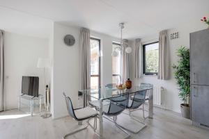 a dining room with a glass table and chairs at 6 - Person 'de Vlaamse Reus' 195 Bungalow in Ewijk +42 photos