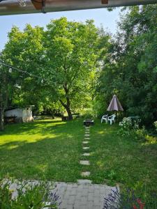 un giardino con un sentiero, un tavolo e una tenda di Birslak a Makkoshotyka