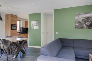 a living room with a couch and a table at 6 - Person Lake Area 28 Bungalow in Ewijk