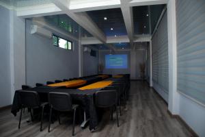 a conference room with tables and chairs and a screen at Noble Hearts Bed & Breakfast in Maseru +25 photos