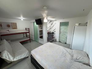 een slaapkamer met twee bedden en een plafondventilator bij Kitnet em Cabo Frio 02 in Cabo Frio