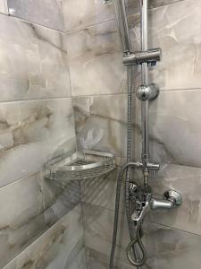 a bathroom with a shower with a hose at Inaya Apartman Free Parking in Sarajevo +57 photos