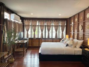 een slaapkamer met een bed en een bureau erin bij The Memory Hostel Trat in Trat