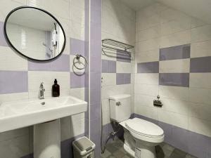 een badkamer met een toilet, een wastafel en een spiegel bij The Memory Hostel Trat in Trat +90 foto's