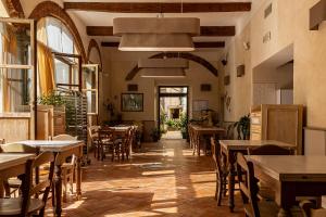 an empty restaurant with tables and chairs and windows at Hostel Archi Rossi in Florence