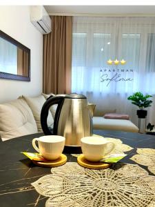 een waterkoker en twee kopjes op een tafel bij Sofema in Pirot