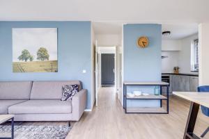 a living room with a couch and a table at 4 - Person Lakeside 47 Bungalow in Ewijk