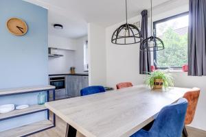 a kitchen and dining room with a wooden table and chairs at 4 - Person Lakeside 47 Bungalow in Ewijk
