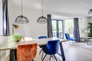 a dining room with a wooden table and blue chairs at 4 - Person Lakeside 47 Bungalow in Ewijk +30 photos