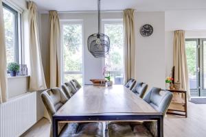 a dining room with a table and chairs at 6 - Persons Lake Area 40 Bungalow in Ewijk +41 photos
