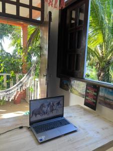 a laptop computer sitting on a table next to a window at Casa na Floresta in Itacaré