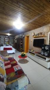 una grande camera con due letti e una TV a schermo piatto di Pousada e Residencial Linda a Capão da Canoa