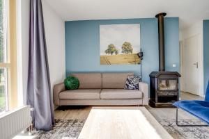 a living room with a couch and a wood stove at 5 - Person Forest 239 Sauna Bungalow in Ewijk