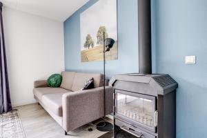 a living room with a couch and a stove at 5 - Person Forest 239 Sauna Bungalow in Ewijk