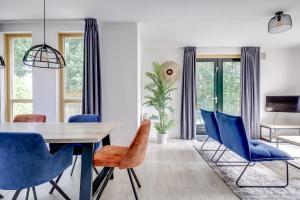 a dining room with a table and blue chairs at 5 - Person Forest 239 Sauna Bungalow in Ewijk +35 photos